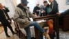 Захватившие правительственное здание протестующие сняли портрет президента Кыргызстана Сооронбая Жээнбекова, один из мужчин выбивает его из рамы. Бишкек, 6 октября 2020 года.