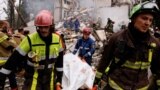 Спасатели несут тело на месте обстрела жилого дома российскими ракетами и беспилотниками во время атаки России на Украину в Киеве, Украина, 31 июля 2025 года