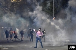 Demonstranții înconjurați de nori de gaze lacrimogene în timpul protestelor anti-guvernamentale de la Belgrad, pe 16 august 2025.
