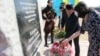 Люди возлагают цветы у памятной стелы Ахмаду Кадырову. Поселок Малая Сарань Карагандинской области. 23 августа 2012 года. 