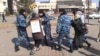 Полиция уводит жительницу Астаны Алтын Червалиеву, которая проводила пикет против сноса ее жилья. 3 апреля 2014 года.
