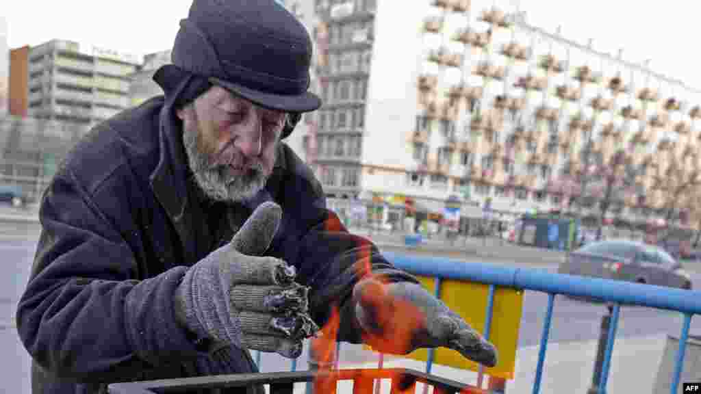 Безпритульний гріється біля вогню на вулиці Варшави