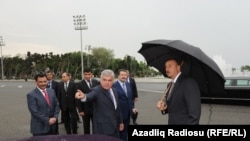 Azerbaýjanyň transport ministri Ziya Mämmedow, "Baghlan Group" toparynyň ýolbaşçysy Hafiz Mämmedow prezident Ylham Alyýewe Londondan getirilen taksileri görkezýärler.