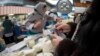 Покупатель у прилавка с молочной продукцией на Зеленом базаре в Алматы.