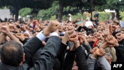Demonstranti drže svoje ruke sa lisicama na rukama i izvikuju parole ispred MUP-a u Tunisu, 14. januar 2010.