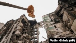 Плюшено мече виси на прекършен клон на дърво в Бородянка, близо до Киев.