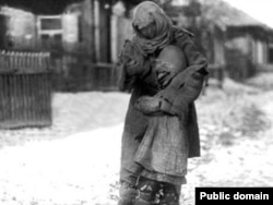 1930-жылдардагы ачарчылык маалында баласын бооруна кысып бараткан аял.