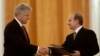 Russian President Vladimir Putin (right) and US President Bill Clinton exchange agreements on the establishment of a joint warning center for the exchange of information on missile launches shortly after signing them, in Moscow on June 4, 2000.