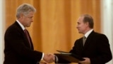 Президент Росії Володимир Путін (праворуч) і 42-й президент США Білл Клінтон обмінюються угодами про створення спільного центру попередження для обміну інформацією про запуски ракет невдовзі після їх підписання в Москві, 4 червня 2000 року