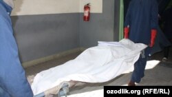 Сүрөттө: Өзбек түрмөсүндө көз жумган адамды сыртка чыгарышууда