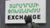 Armenia - A schoolboy walks past a currency exchange sign in Yerevan, 17Dec2014.
