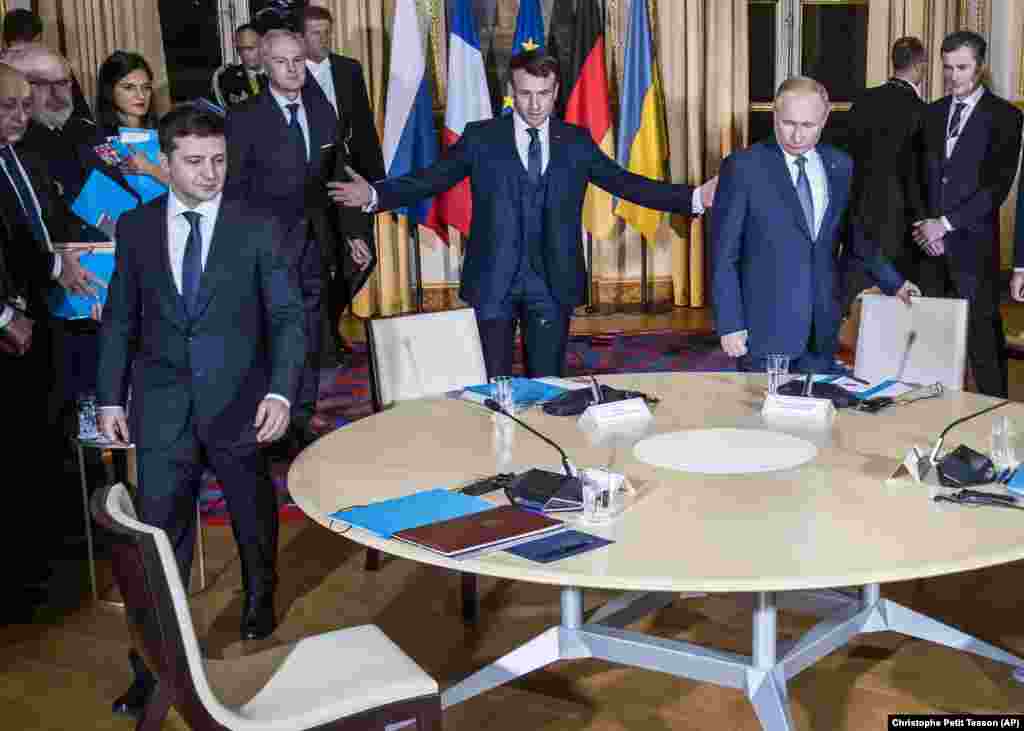Russian President Vladimir Putin (right), French President Emmanuel Macron (center), and Ukrainian President Volodymyr Zelenskiy gather at the Elysee Palace in Paris on December 9. It was the first meeting for Putin and Zelenskiy in an attempt to end five years of fighting in the Donbas region of eastern Ukraine controlled by pro-Russia separatists. (Pool via AP/Christophe Petit Tesson)