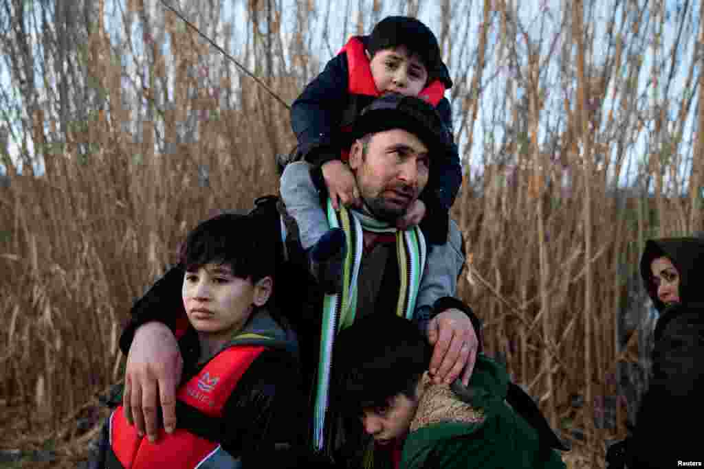 Një burrë mban tre fëmijët e tij.&nbsp; Shumë kampe migrantësh në Greqi janë të mbipopulluara.&nbsp;Në ishujt grekë aktualisht ndodhen mbi 42,000 migrantë.