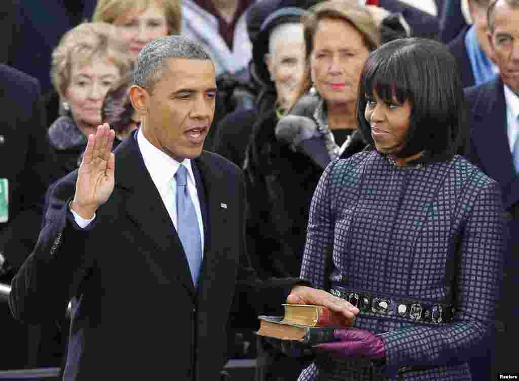 Obama polaže zakletvu na Bibliji koju drži američka prva dama Michelle Obama