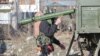 An Indian Army soldier carries a rocket launcher near the site of a gunbattle between suspected militants and Indian security forces in Pinglan village in south Kashmir's Pulwama district on February 18.
