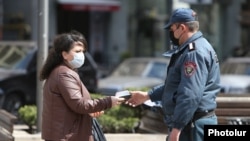 Полицейский проверяет документы гражданки, 25 марта 2020 г.