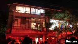 Ljudi, spasioci i pripadnici bezbjednosti na mjestu udara iranskog raketnog napada, u Ramat Ganu, 13. juna