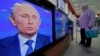 Кибеттәге бер ханым Путин чыгышын күзәтә