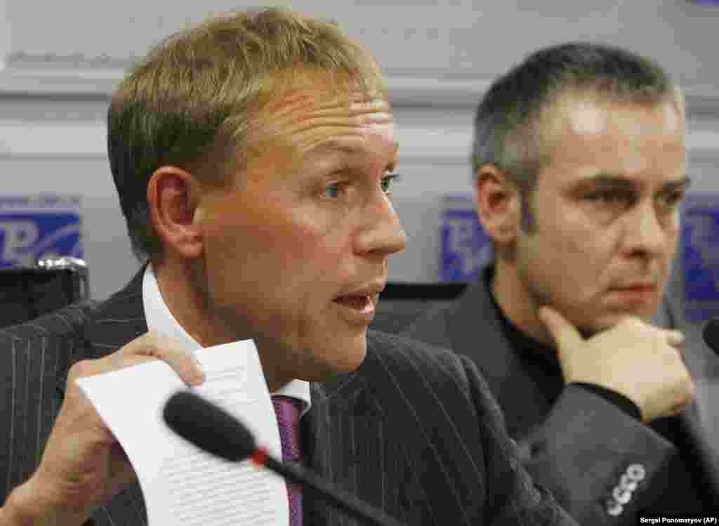 Andrei Lugovoi (stânga), fost ofițer KGB, și asociatul său Dmitri Kovtun, participă la o conferință de presă la Moscova, la 1 noiembrie 2007. O anchetă britanică a concluzionat în 2016 că președintele rus Vladimir Putin a aprobat probabil o operațiune a serviciilor secrete pentru&nbsp; asasinarea lui Litvinenko. Ancheta britanică i-a identificat pe Lugovoi, acum un parlamentar rus, și pe Kovtun drept principalii suspecți. &nbsp;