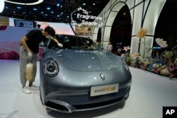 Hytaýyň Şanhaý şäherindäki Milli kongres we sergi merkezinde 2023-nji ýylda geçiriljek Şanhaý awtoulag bazarynda, bir işçi hytaý elektrik ulagy “Ora” maşynyny süpürýär, 2023-nji ýylyň 18-nji apreli.
