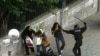 An Iranian riot-police officer attacks a man with a baton near Tehran University on June 14. Mir Hossein Musavi has urged his supporters to continue their protests in a "peaceful and legal way" and urged police to refrain from violence.