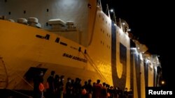 Migranti hodaju prema karantenskom brodu Snav Adriatico nakon što su se iskrcali s broda njemačke nevladine organizacije za spašavanje migranata Sea-Watch 3 nakon što je stigao sa 257 spašenih migranata na brodu, u Trapaniju na ostrvu Sicilija, Italija, 7. augusta 2021.