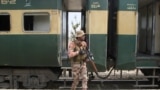 Pakistan goşunynyň esgeri 12-nji martda Bulujystanyň Muşkaf demir ýol menzilinde halas ediş otlusynyň ýanynda dur.