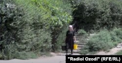 Täjigistanyň Kulýab şäheriniň ýaşaýjysy bedreli suw daşaýar.