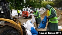 Gép segítségével töltik a homokzsákokat a Fővárosi Csatornázási Művek munkatársai a Margit-szigeten 2024. szeptember 16-án