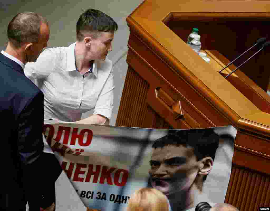 Cu un gest „milităresc” a rupt un afiș cu chipul ei din detenţie de pe tribuna Radei şi l-a înlocuit cu unul pe care sunt scrise numele celor rămaşi în Rusia.
