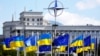 Steaguri ale Ucrainei și Uniunii Europene, sub emblema NATO, în Piața Europei din Kiev (iulie 2023) 