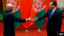 Chinese Prime Minister Li Keqiang greets Afghan President Ashraf Ghani (L) before their meeting at the Great Hall of the People in Beijing in late October.