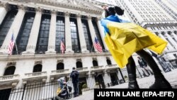 Statuia „Fetei neînfricate” acoperită cu steagul ucrainean în fața Bursei de la New York, 4 mai 2022
