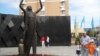 Мужчина с детьми стоит у нового памятника, открытого в честь памяти жертв Голодомора. Астана, 31 мая 2012 года. 