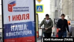 People walk past a billboard advertising a nationwide vote on constitutional changes, in Novosibirsk, June 10, 2020