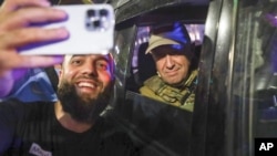 Liderul grupului Wagner, Evgheni Prigojin, face un selfie alături de un tânăr rus dintr-un oraș în care grupul paramilitar rus a ajuns în timp ce mărșăluia spre Moscova. 