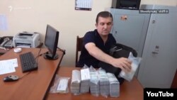 Armenia - Vachagan Ghazarian empties his bag filled with cash after being arrested by the National Security Service in Yerevan, 25 June 2018.